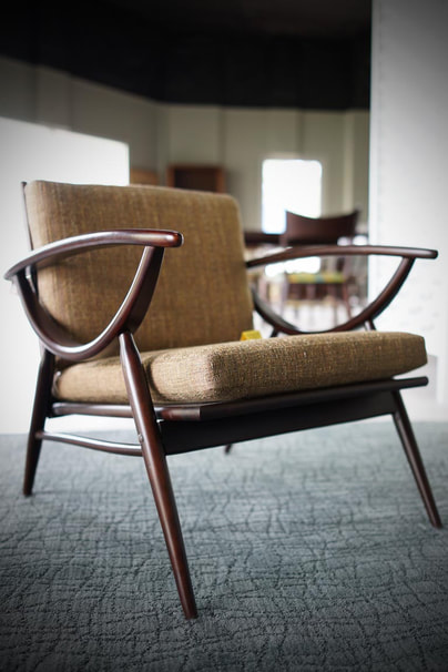 Vintage Danish Modern bentwood arm chair with tweed upholstery on a sculptured mist blur area rug flooring.