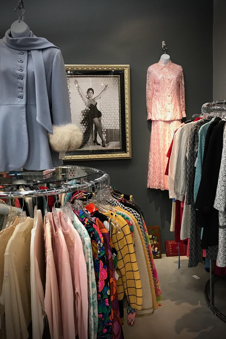 Vintage Mid-Century dresses, jackets, shirts, pants and other clothing on display racks